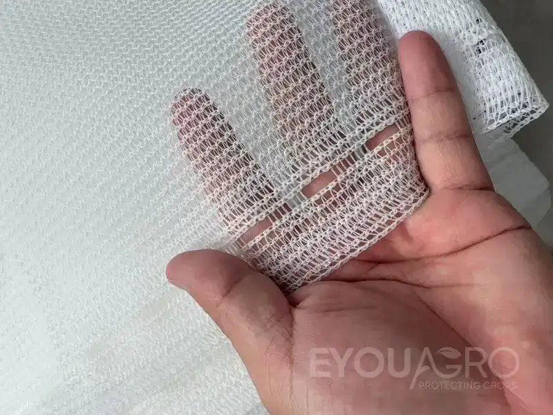 A loom at the EyouAgro factory weaving clean, white 50% shade netting.