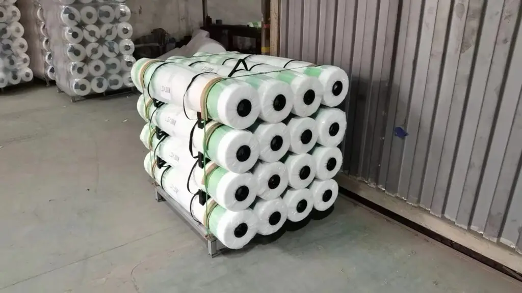 Finished rolls of bale net wrap stacked and secured on a custom pallet for shipment to Japan
