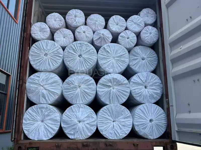 the eyouagro team loading large rolls of red shade netting into a 40'hq container.