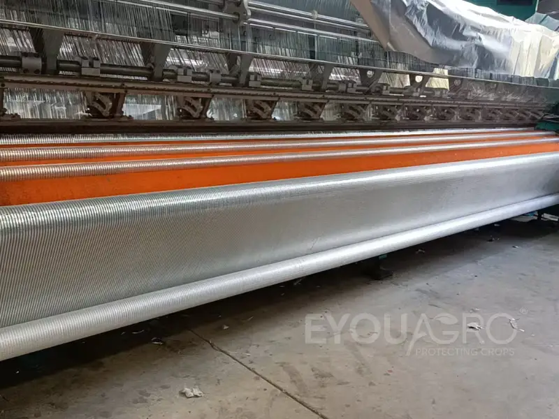 A specialized loom weaving reflective Aluminet screen fabric at the EyouAgro factory.